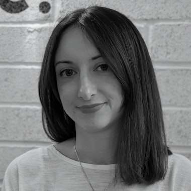 a woman standing in front of a brick wall